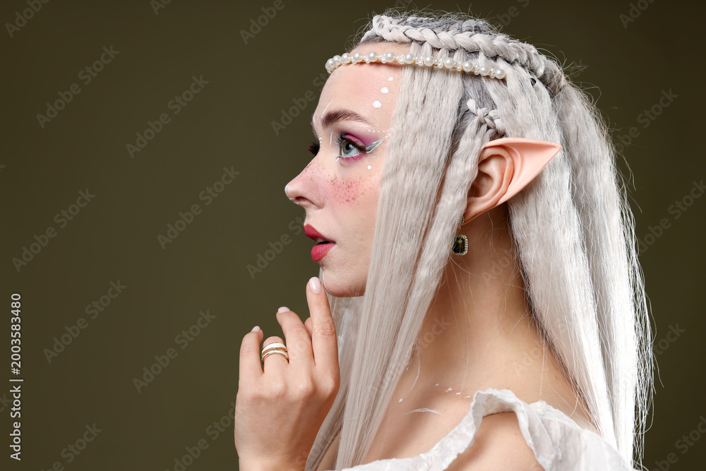 Fototapeta premium Beautiful elf girl on dark olive background, space for text