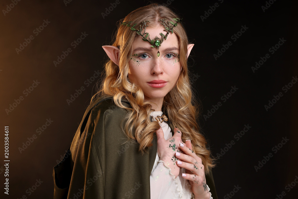 Fototapeta premium Beautiful elf girl on black background with smoke