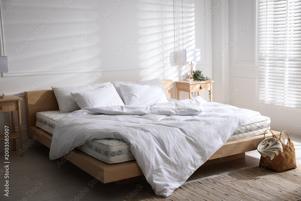 Fototapeta premium Orthopedic mattress, pillows and duvet on bed indoors. Space for text