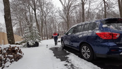 Time-lapse woman cleaning the car after the snow storm in February