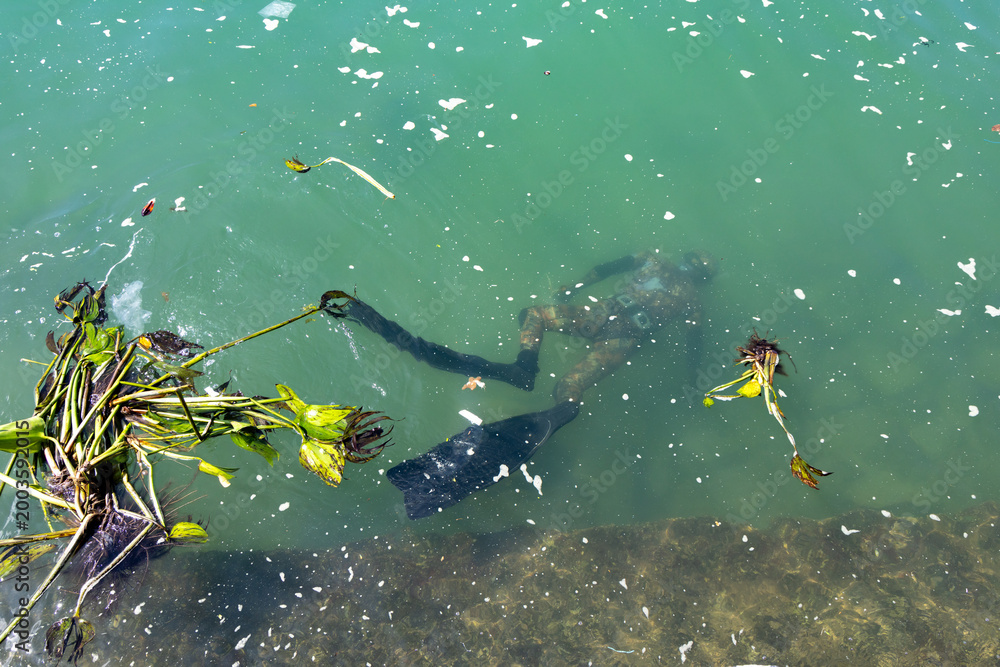 Ταπετσαρία A diver in camouflage gear explores the murky waters the harbour in Hon Mieu, Nh