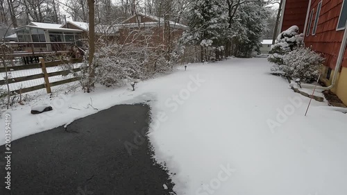 walking in driveway partly covered with snow after the snowfall in February