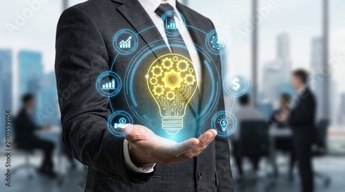 A businessman in a suit holding a glowing digital light bulb with gears and data icons, symbolizing innovation and technology in a modern office setting.