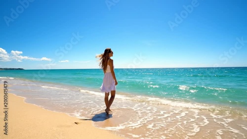 Serene Woman Walking Along Tropical Beach with Turquoise Ocean Waves and Clear Blue Sky, Slow Motion Footage, symbolizing relaxation and tranquility
