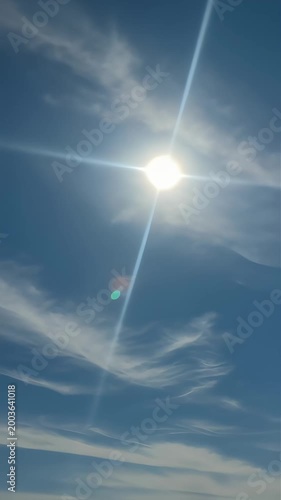The strong sunlight shining in the blue sky and flowing clouds