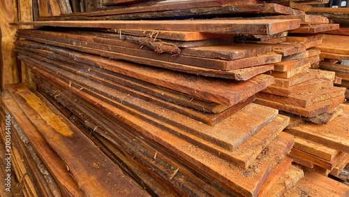 Bild auf Leinwand Stacked Wooden Planks with Sawdust – Lumber Industry and Construction Material
