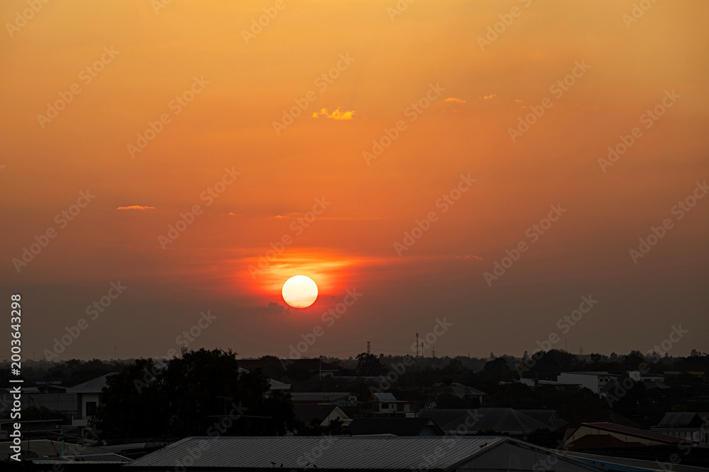 Obraz premium Golden hour sunset glow over urban city rooftops at twilight