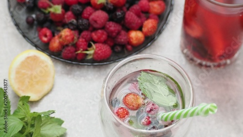 Summer drinks, colored cocktails on table. Lemonade, mojito, strawberry lemonade, tonic water. A refreshing summer drink with raspberries and blueberries, a detox drink for weight loss and keeping fit
