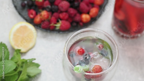 Summer drinks, colored cocktails on table. Lemonade, mojito, strawberry lemonade, tonic water. A refreshing summer drink with raspberries and blueberries, a detox drink for weight loss and keeping fit