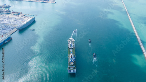 Foto luxury cruise ship escorted by three tugboats in clear turquoise ocean water