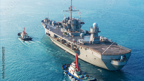 Fotografie large naval amphibious assault ship being assisted by tugboats in the strategic Strait of Hormuz
