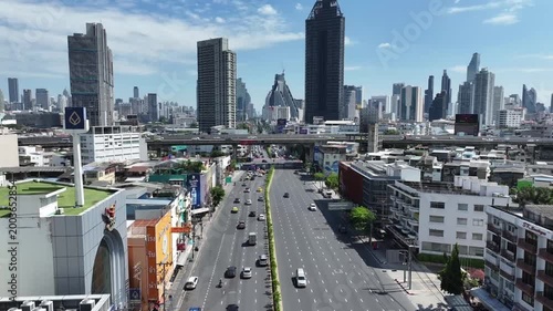 Rama 4 Road with vehicles moving along wide multilane street. Urban buildings and elevated road align with city transportation structure.