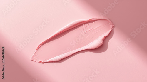 Soft pink cream smear on matte surface evoking gentle beauty and calm light