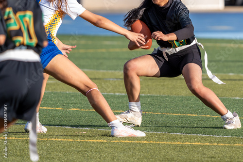 Bild auf Leinwand Flag football athlete running the ball attempts to evade tackle