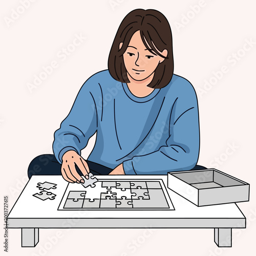 Girl sitting on floor concentrating on assembling complex jigsaw puzzle.