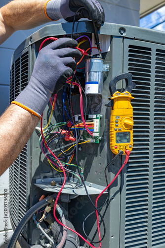 Принти на полотні HVAC technician testing an outdoor AC unit capacitor with a multimeter, USA