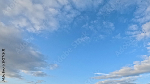 Bild auf Leinwand Wide Angle View of White and Grey Clouds Across Blue Sky