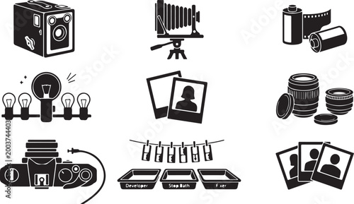 Set of black and white featuring vintage cameras, rolls, camera lenses, light bulbs, instant and darkroom developing trays with chemical baths and hanging strips