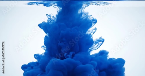 Vivid blue ink swirling dramatically in clear water, creating mesmerizing patterns and textures