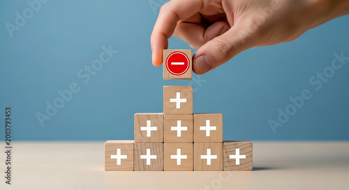 Negative Perspective: A symbolic arrangement of wooden blocks, one marked with a minus sign positioned to alter the positivity of the pyramid structure.