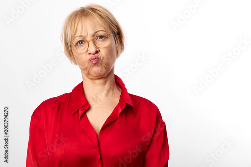 Foto Funny woman with short blond hair and eyeglasses, red shirt on white background,