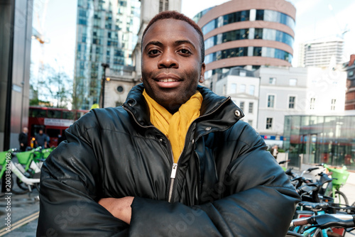 Photography African man smiling, crossing arms in london city street