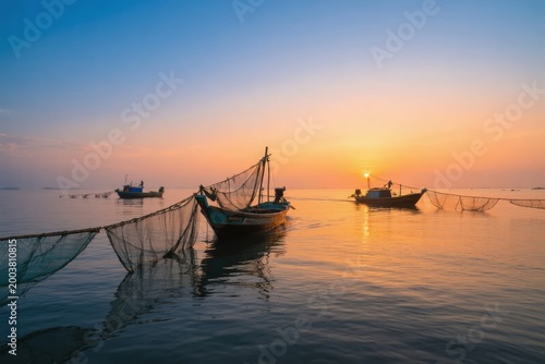 Fishing boats at sunset on calm waters with nets extending into the sea