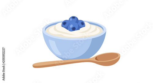 A bowl of creamy yogurt topped with fresh blueberries and a wooden spoon