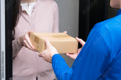 若い女性と宅配業者の荷物の受け渡し　ライフスタイルイメージ
