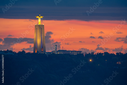 Fotografie Cristo Rei Statue Illuminated at Sunset in Lisbon | Glowing Christ Monument Agai