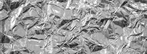 Obraz na plátně Close-up of crumpled aluminum foil showing shiny metallic wrinkles and reflective highlights, ideal as an abstract background or texture for industrial, packaging, food, and modern design projects