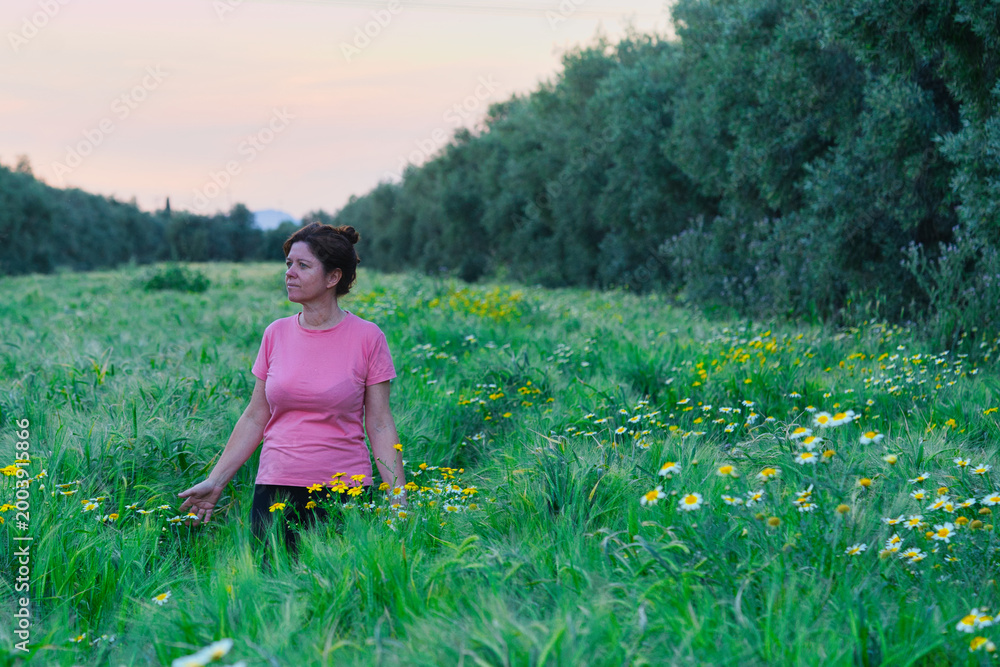 Fototapeta premium Woman enjoys a walk in some cereal fields