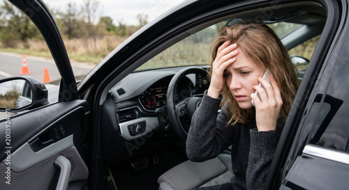 Young woman calling for help after car accident on roadside