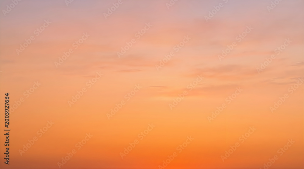 Fototapeta premium Warm orange sunset sky with soft clouds