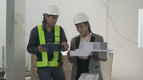 Foto Engineers and architect discussing house model at construction site