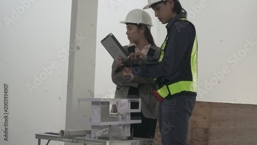 Engineers and architect discussing house model at construction site