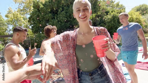 Nonbinary adult taking red cup from cam bumping hands twirling pool social grill confetti overlay