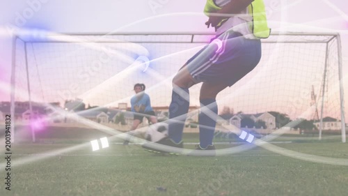 Bib player running, shooting ball at goal GK shifting light streaks sweeping players sports-drill