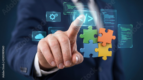 Businessman touching coding icon with colorful puzzle pieces, custom software development and system integration concept, modular application programming and cloud technology