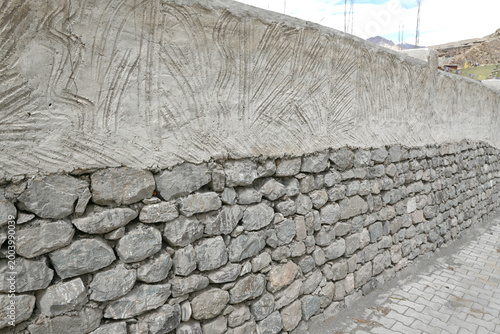 A two-toned wall blending natural stones with decorative cement.