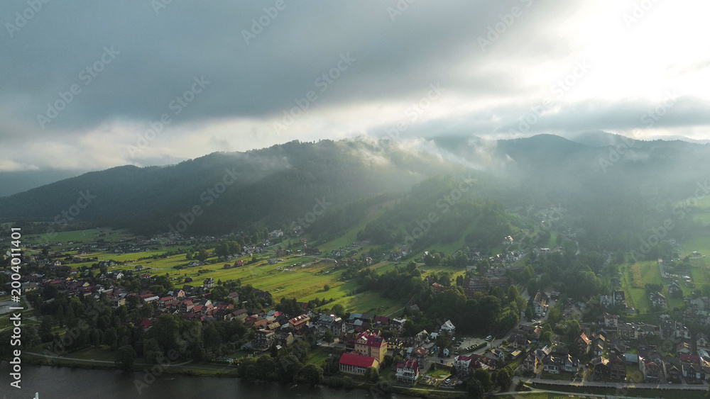 Obraz premium Morning fog above tranquil green hillside community