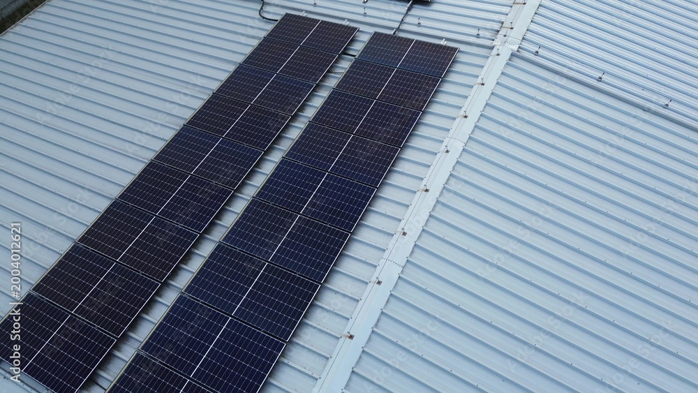 Fototapeta premium Solar panel array on large warehouse structure