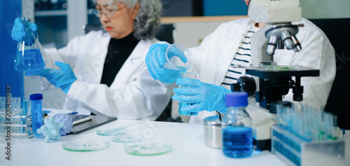 Scientists in laboratory conducting research, analyzing samples with microscope and data, healthcare innovation, medical testing