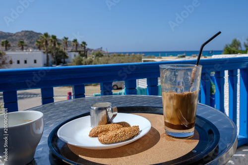 Having a Greek iced frappé coffee and Greek delicious cookies on the balcony in Ios Greece