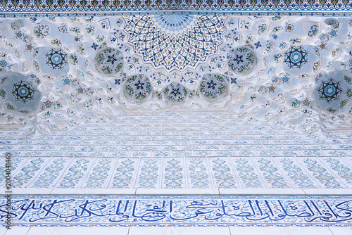 Ornate muqarnas ceiling with painted tilework and Arabic calligraphy inside Minor Mosque in Tashkent. Ideal for travel publications, architectural studies, and cultural heritage projects.