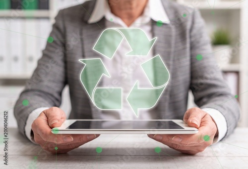 Business Person Holding Tablet with Recycling Symbol in Office Setting