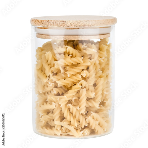 Foto Pasta in a glass jar with a wooden lid isolated on white background