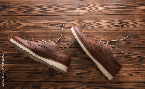 Photos Brown Leather Men's Brogue Shoes on Wooden Floor. Top view