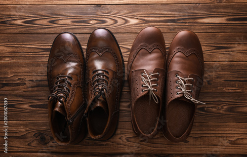Bild auf Leinwand Two pairs of brown classic shoes on wooden background