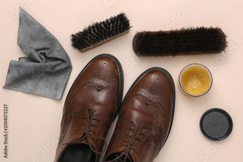Obraz na plátne Shoe care products and leather shoes on a beige background